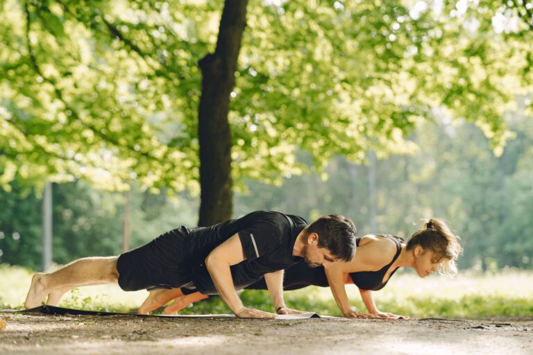 Two people doing push-ups outdoors during a bodyweight workout