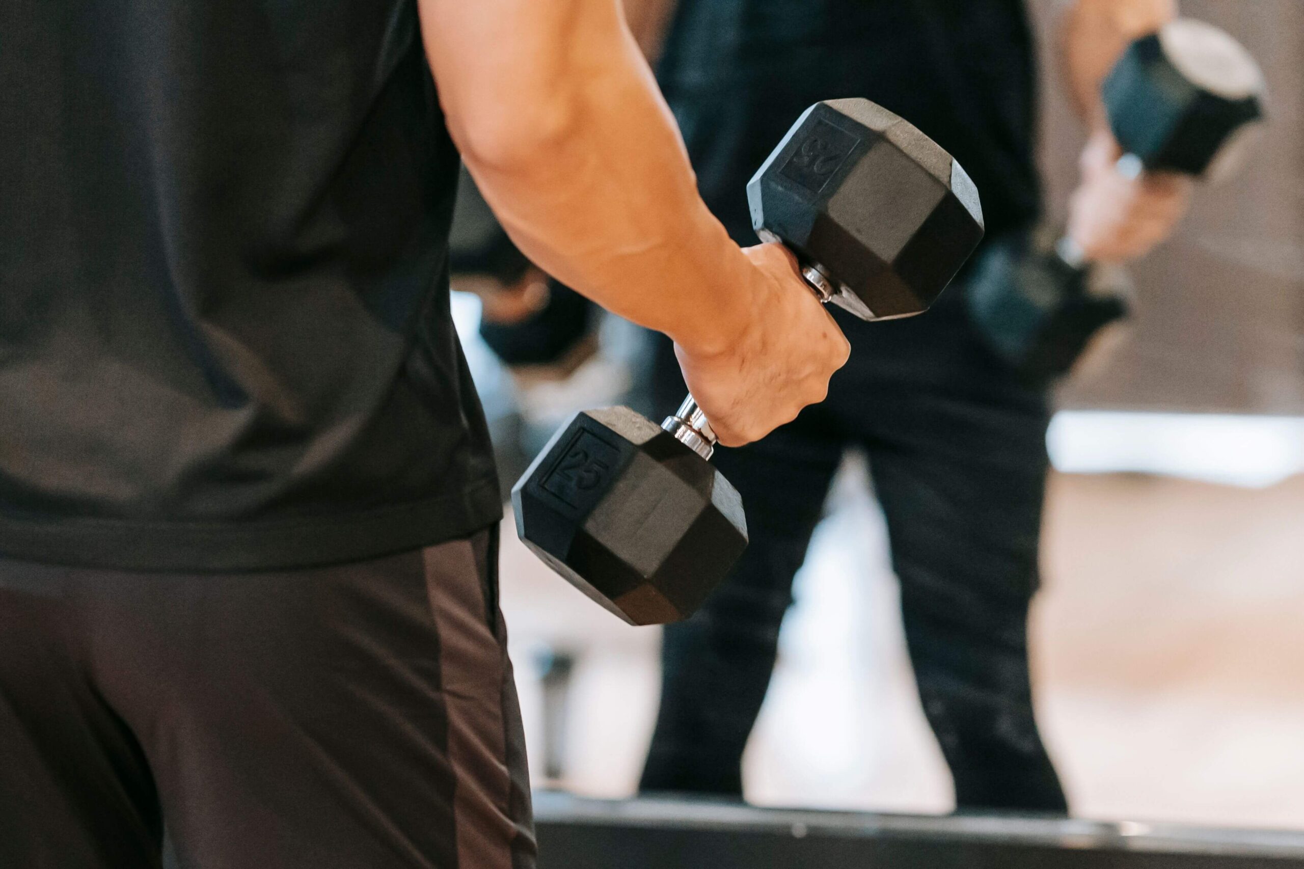 Person pausing mid workout doing dumbbell workouts, looking fatigued and unmotivated in a home gym