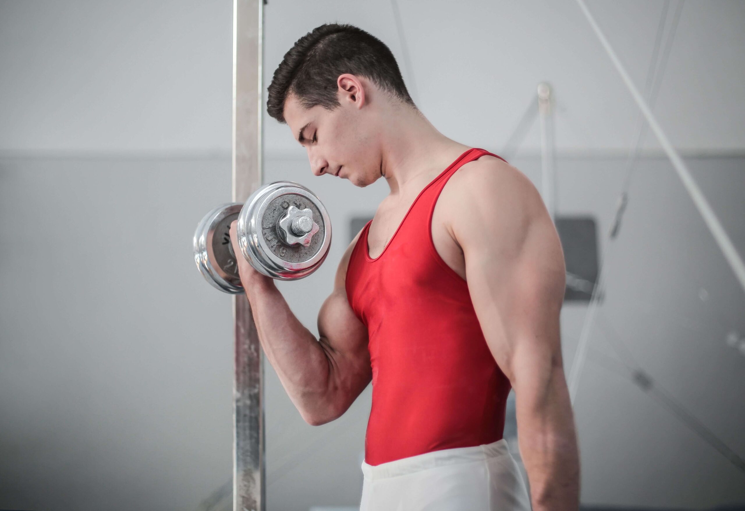 Man performing a dumbbell bicep curl indoors