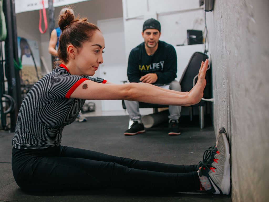 woman performing a dumbbell hip thrust, a key movement in a resistance training for cellulite routine